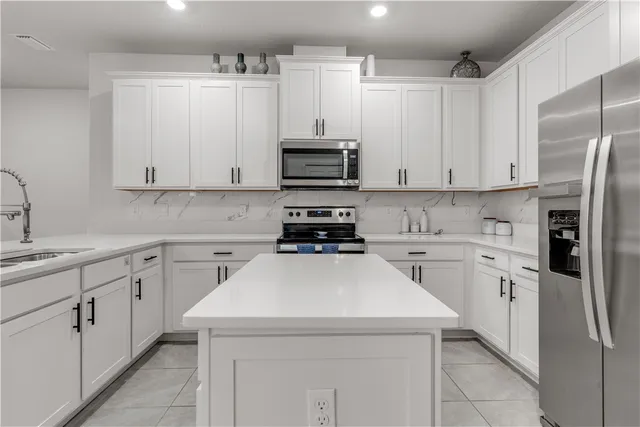 a kitchen with cabinets appliances a sink and a counter top