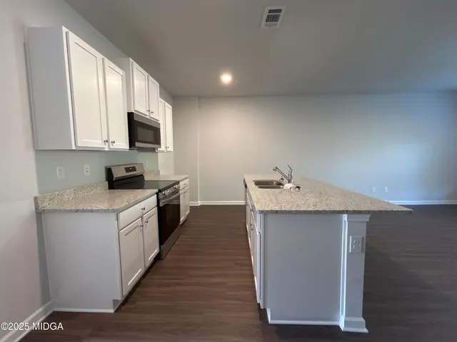 a kitchen with a sink stove top oven and cabinets