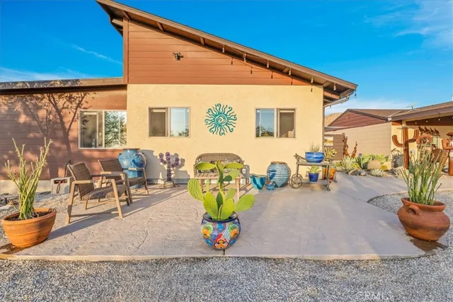 a view of a patio with table and chairs and potted plants