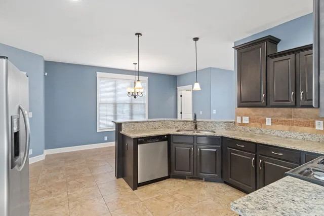 a kitchen with stainless steel appliances granite countertop a sink refrigerator and microwave