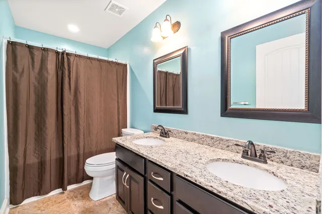 an empty room with windows and chandelier fan