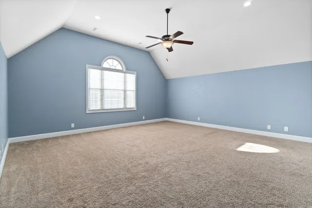 an empty room with a ceiling fan and a window