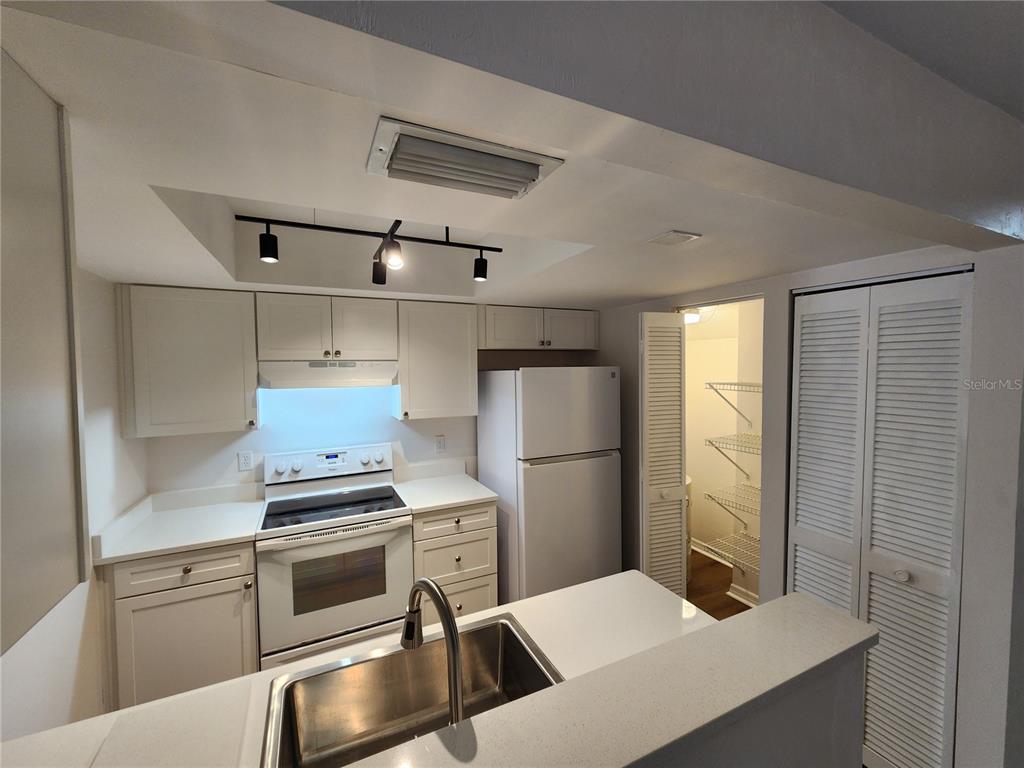 5823 Southwest 9th Place, Unit H55 Gainesville, FL 32607 - Photo 13 of 50 a kitchen with white cabinets and stainless steel appliances