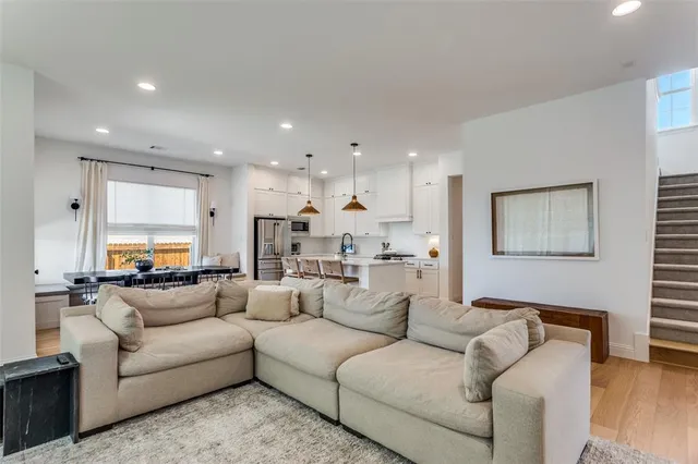 a living room with furniture white cabinets and couches