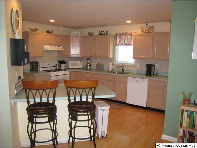 144 Yeoman Road Manahawkin, NJ 08050 - Photo 3 of 3 a kitchen with stainless steel appliances a sink a stove a table and chairs