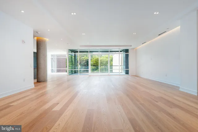 a living room with stainless steel appliances kitchen island a large counter top and a refrigerator