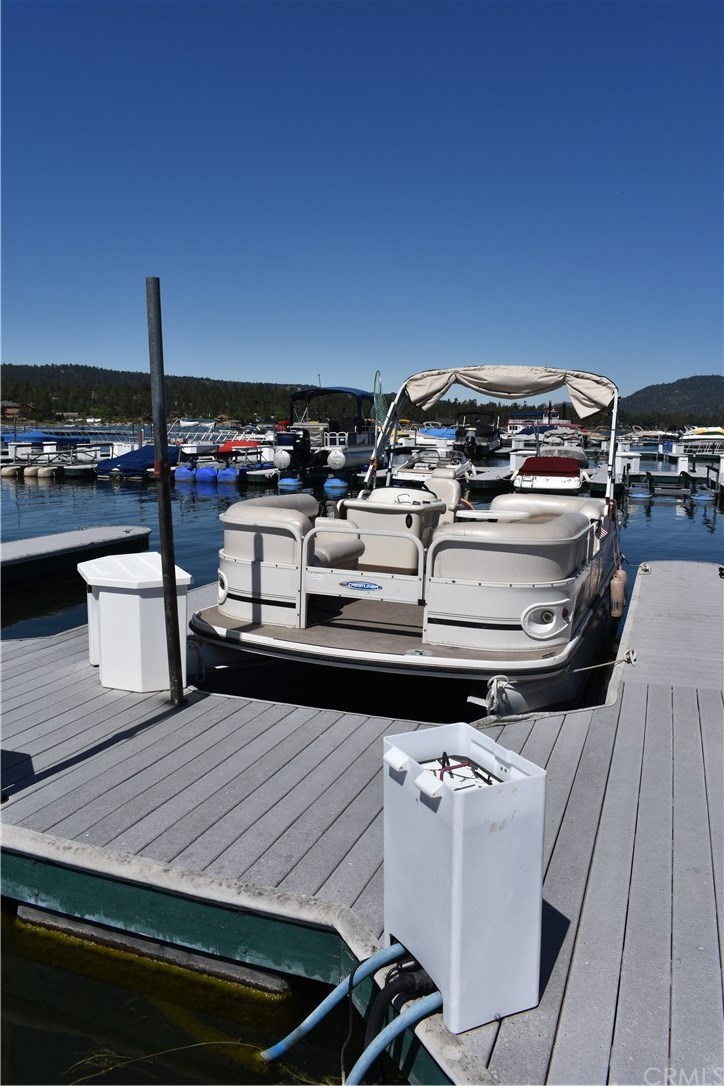 400 Pine Knot Avenue, Unit E20 Big Bear Lake, CA 92315 - Photo 2 of 17 a roof deck with table and chairs a barbeque
