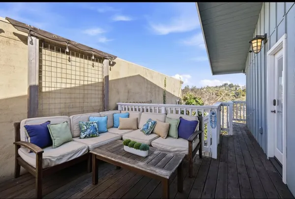 a roof deck with couch and wooden floor