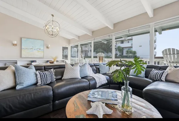 a living room with furniture kitchen view and a large window