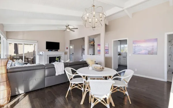 a view of a dining room with furniture a chandelier and wooden floor