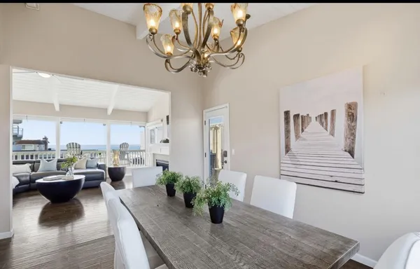 a view of a dining room with furniture a chandelier and wooden floor