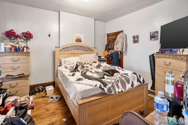 a bedroom with a bed and a flat tv screen on the dresser
