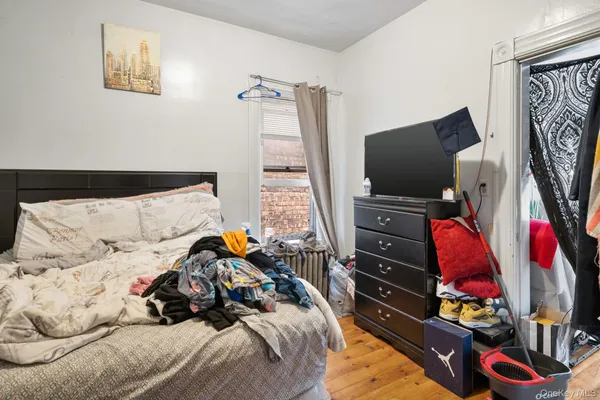 a bedroom with a bed and a flat tv screen on a dresser