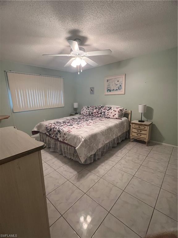 5419 Rattlesnake Hammock Road, Unit 306F Naples, FL 34113 - Photo 12 of 18 a bedroom with a bed and a chandelier