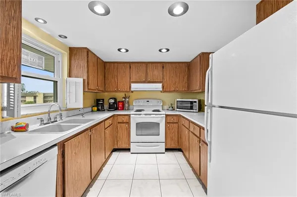 a kitchen with a sink window and cabinets
