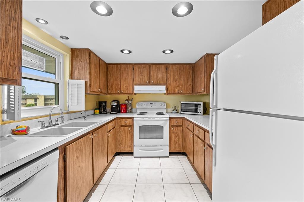5419 Rattlesnake Hammock Road, Unit 306F Naples, FL 34113 - Photo 4 of 18 a kitchen with a sink window and cabinets