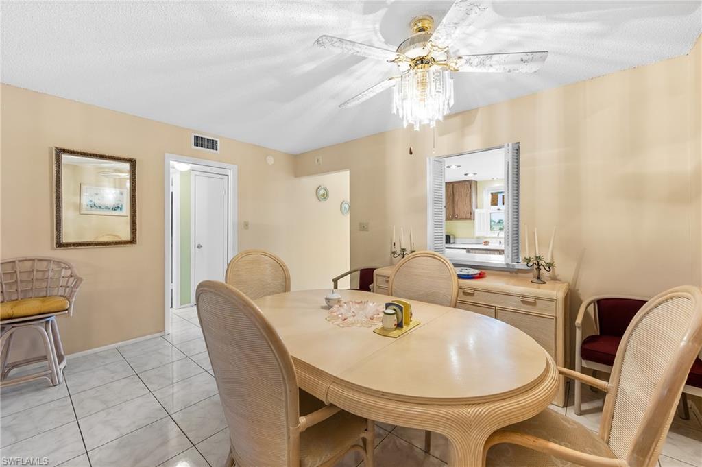 5419 Rattlesnake Hammock Road, Unit 306F Naples, FL 34113 - Photo 7 of 18 a view of a dining room with furniture and a chandelier fan