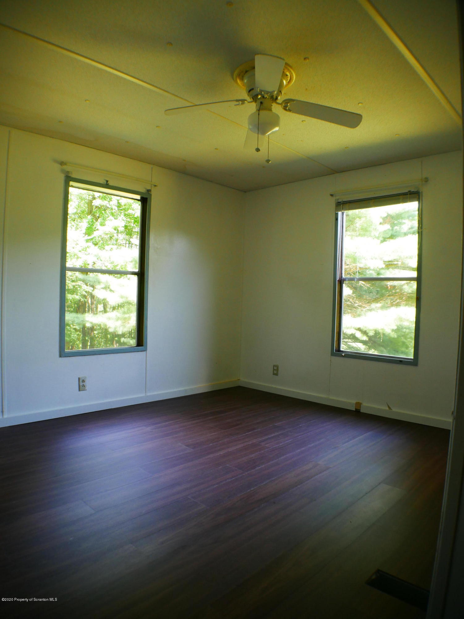 1404 Barrett Road Susquehanna, PA 18847 - Photo 8 of 15 a view of an empty room with wooden floor and a window