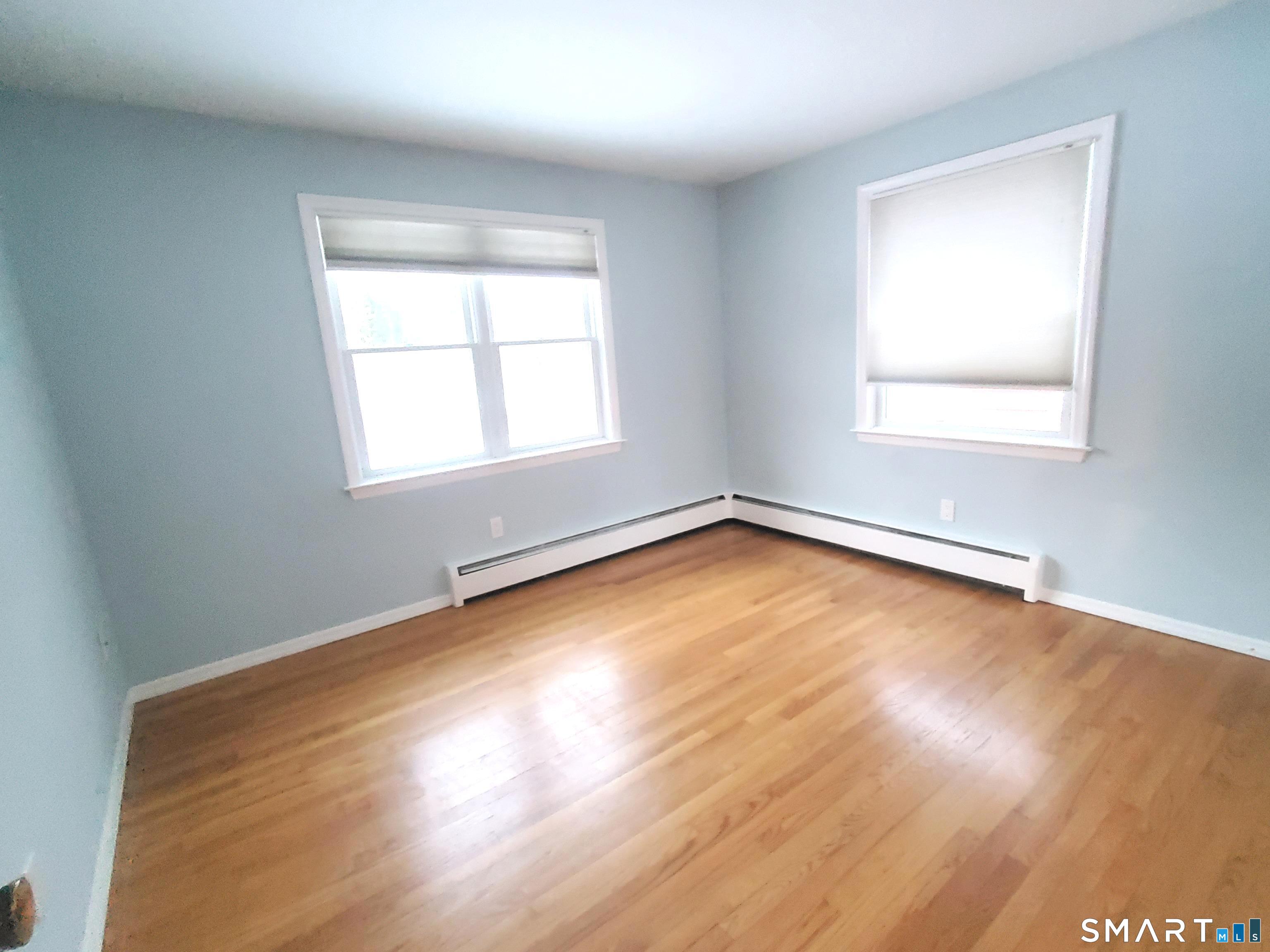 42 County Street Norwalk, CT 06851 - Photo 8 of 21 an empty room with wooden floor and windows