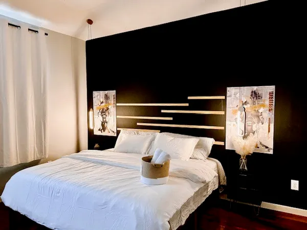 a large bed sitting in a bedroom next to a window