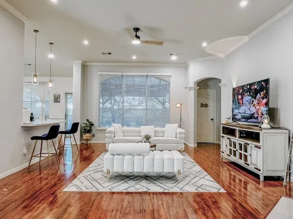 a kitchen with a refrigerator a stove and a sink with wooden floor
