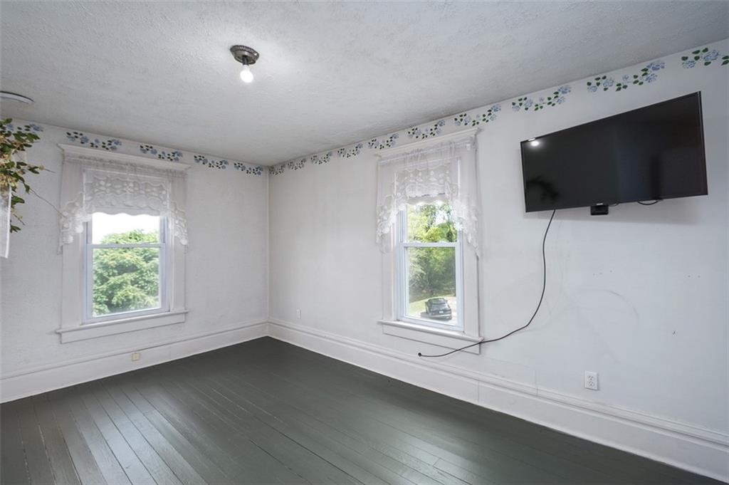114 Cemetery Road Perryopolis, PA 15473 - Photo 25 of 35 en empty room with windows and flat screen tv