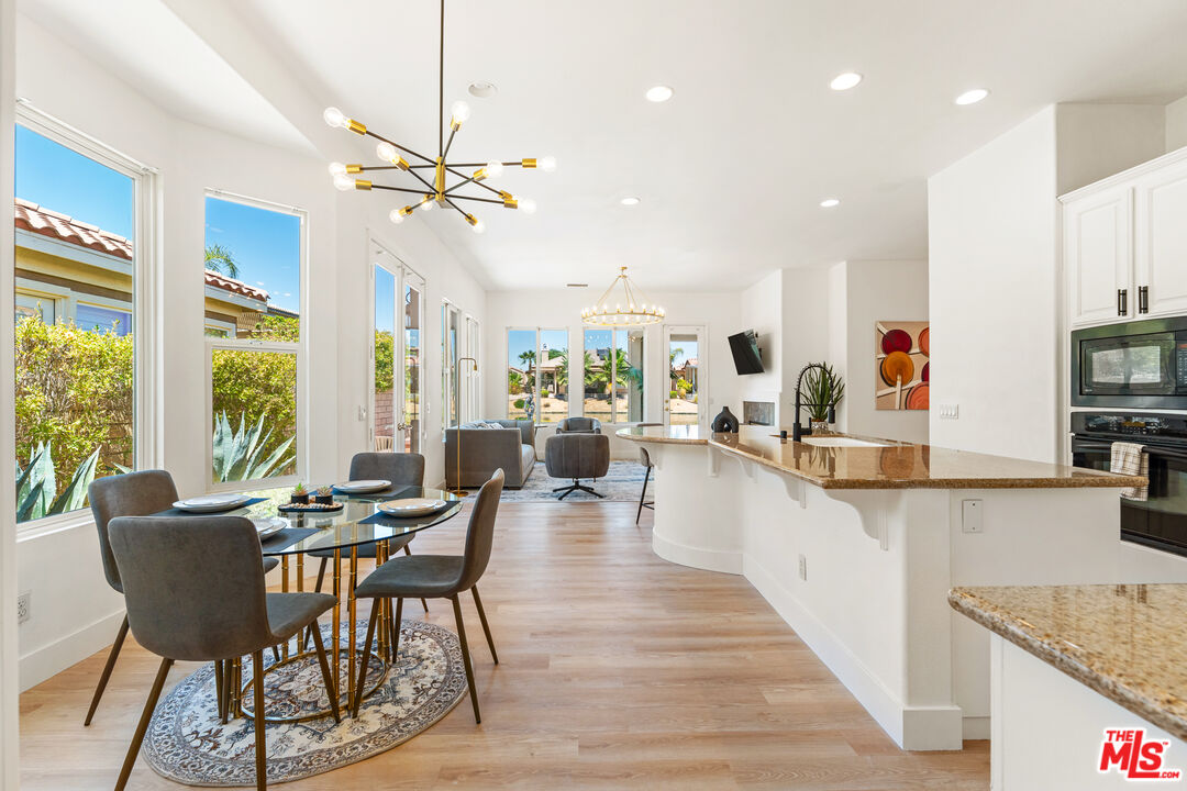 65 Shoreline Drive Rancho Mirage, CA 92270 - Photo 11 of 37 a view of a dining room and livingroom with furniture wooden floor a chandelier