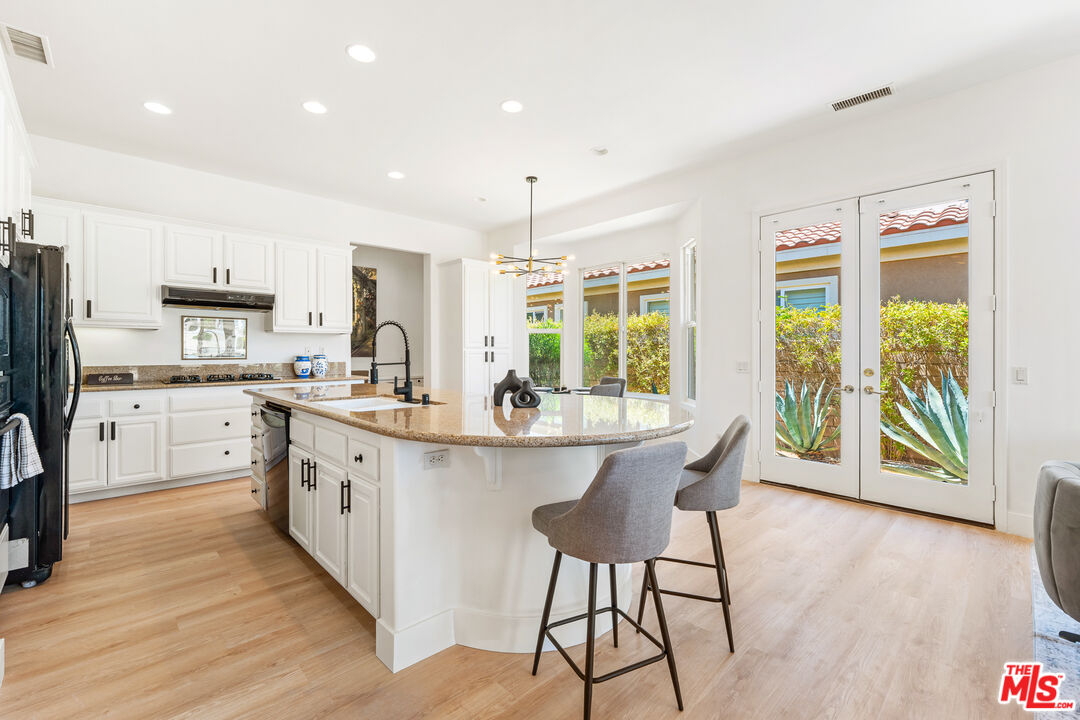 65 Shoreline Drive Rancho Mirage, CA 92270 - Photo 16 of 37 a kitchen with stainless steel appliances granite countertop a stove a sink dishwasher and a refrigerator with wooden floor