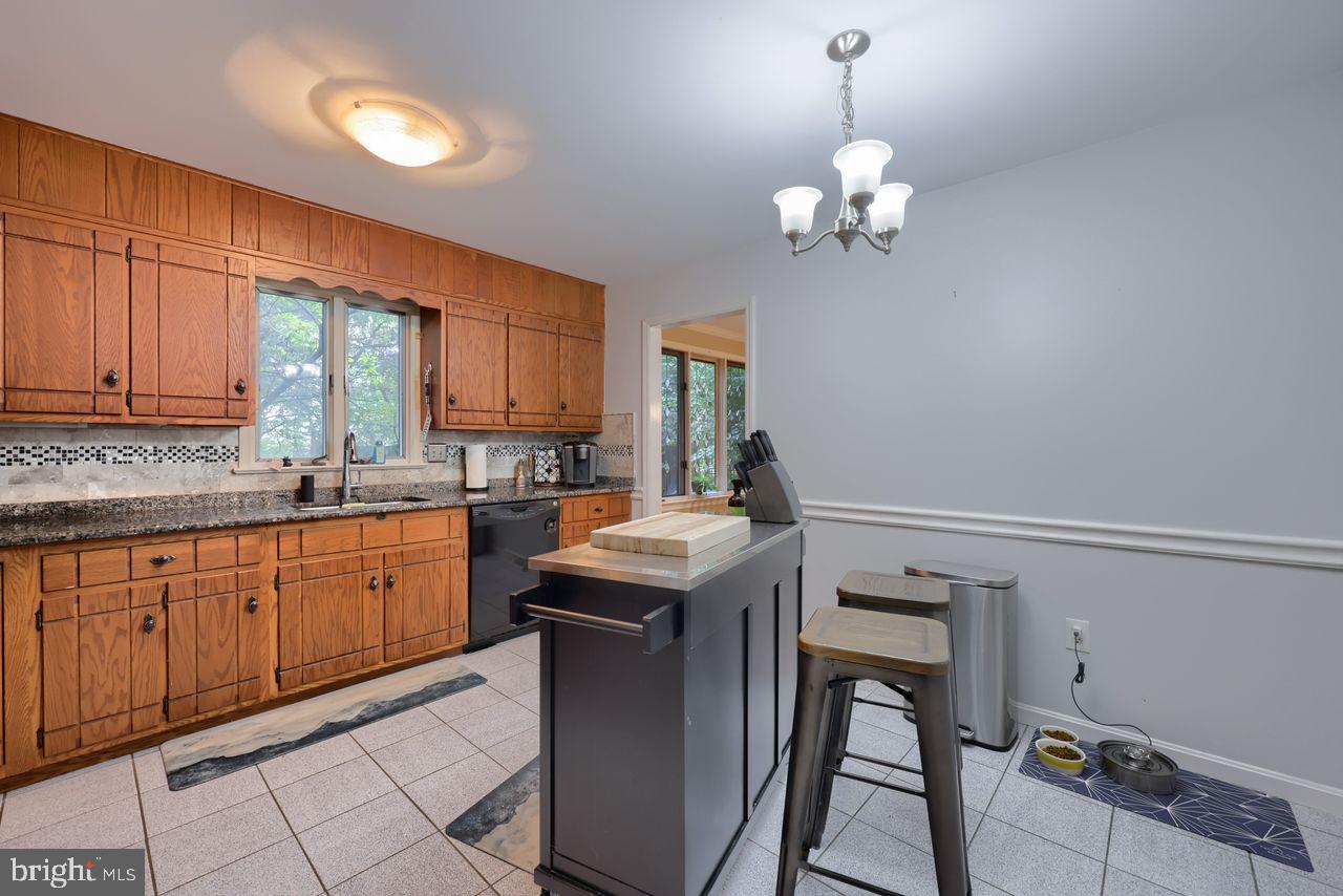 102 Suncrest Road Lancaster, PA 17601 - Photo 21 of 40 a kitchen with granite countertop a stove a sink dishwasher a dining table and chairs with wooden floor
