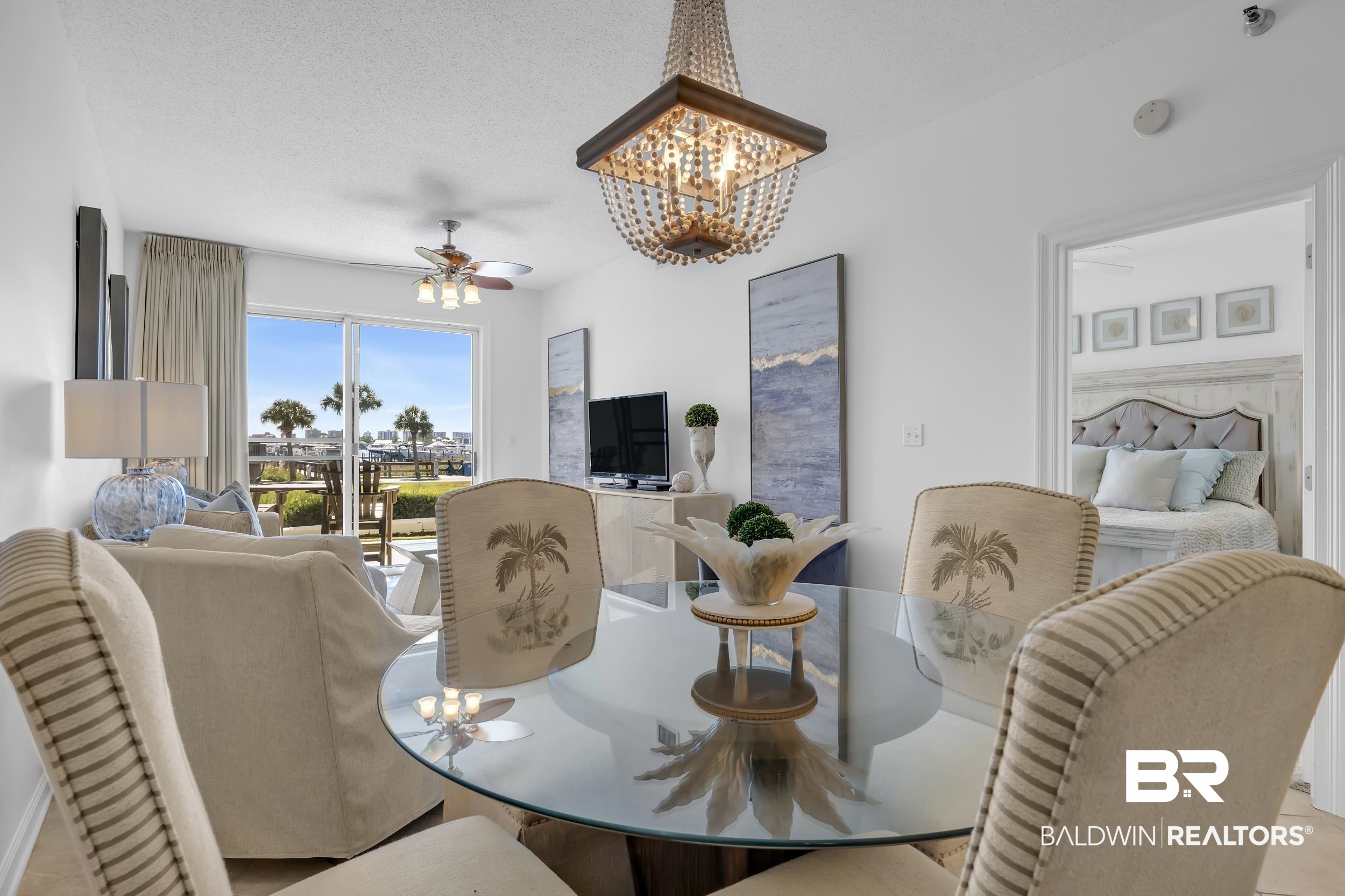 27282 Canal Road, Unit 104 Orange Beach, AL 36561 - Photo 12 of 79 Tiled dining room with a chandelier, a ceiling fan, and a textured ceiling
