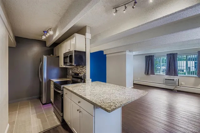 a kitchen with stainless steel appliances granite countertop a sink dishwasher stove and refrigerator with wooden floor