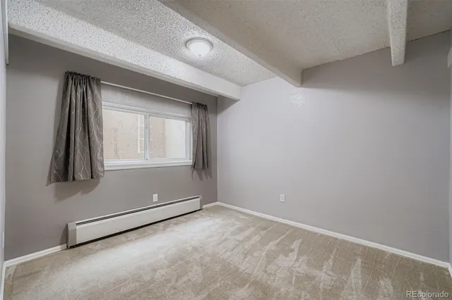 an empty room with a fireplace and windows