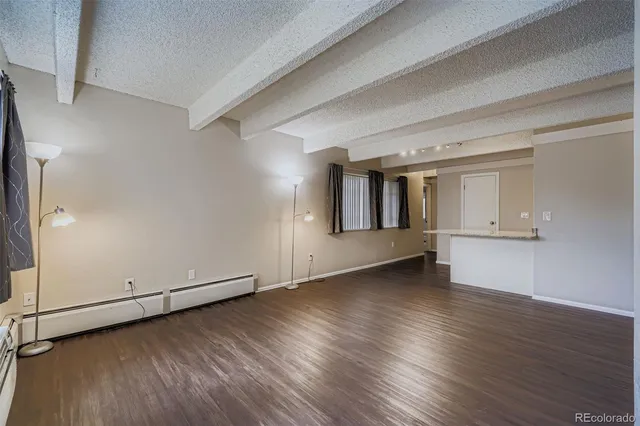 an empty room with wooden floor and white walls