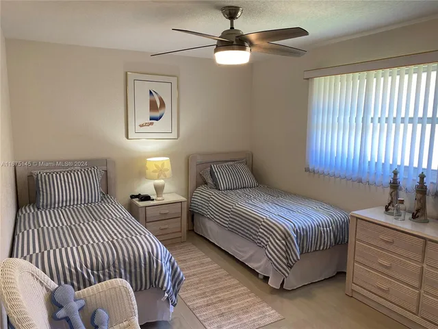 a bedroom with two beds and a chandelier