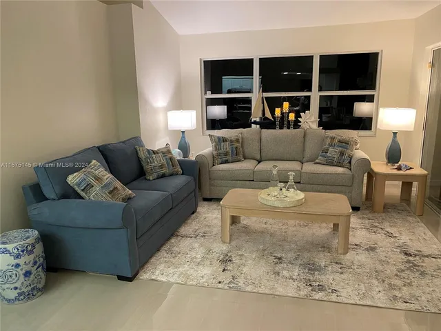a living room with furniture a walk in closet and a large window