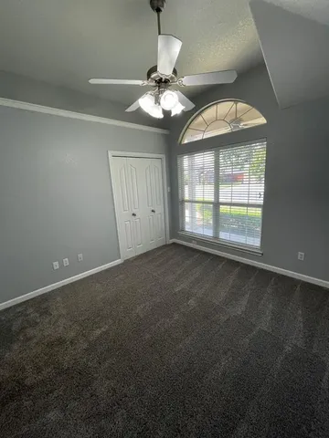 an empty room with a bathroom and a ceiling fan