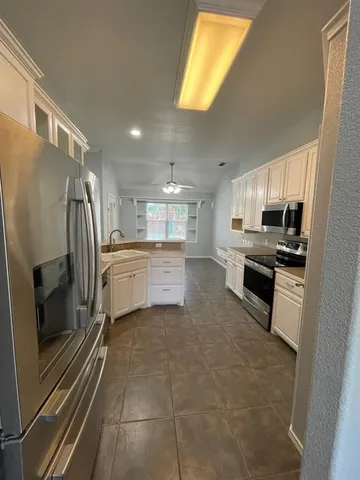 a kitchen with cabinets appliances and a window
