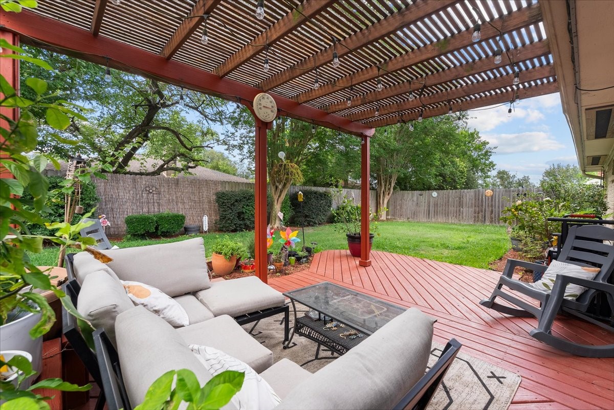 883 Silverpines Road Houston, TX 77062 - Photo 26 of 38 This inviting backyard features a cozy deck with a pergola, comfortable seating,set in a lush, well-maintained garden area perfect for relaxing or entertaining.