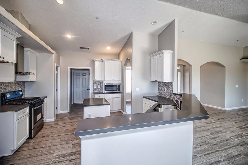 18702 Ranchero Road Hesperia, CA 92345 - Photo 1 of 1 a kitchen with stainless steel appliances granite countertop a sink stove and refrigerator