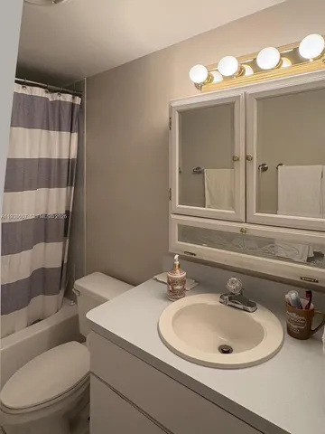 a white toilet sitting next to a shower curtain