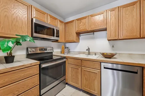 a kitchen with stainless steel appliances a stove microwave and sink