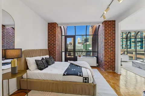 a bedroom with furniture and a large window