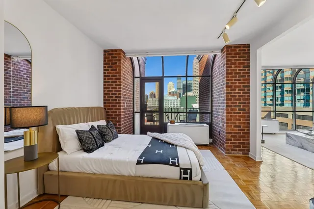 a bedroom with furniture and a large window