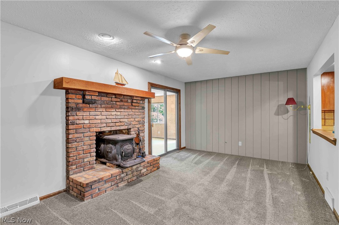 6635 Taylor Road Painesville, OH 44077 - Photo 23 of 41 Brick fireplace with an integrated wood-burning stove and a wood mantel