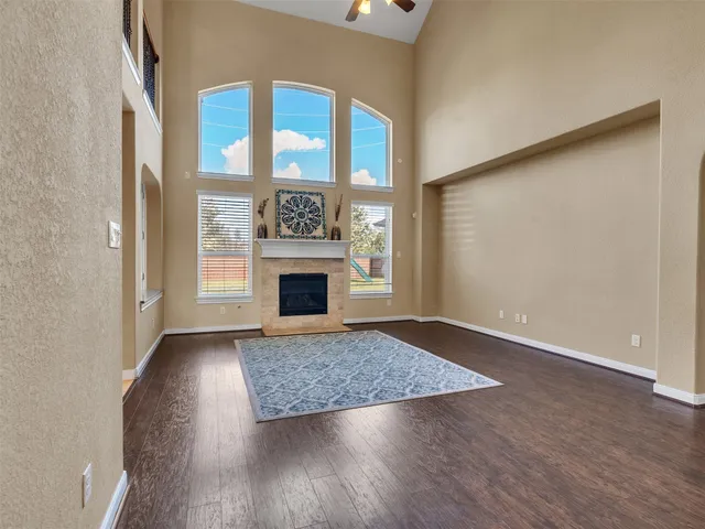 an empty room with windows and fireplace