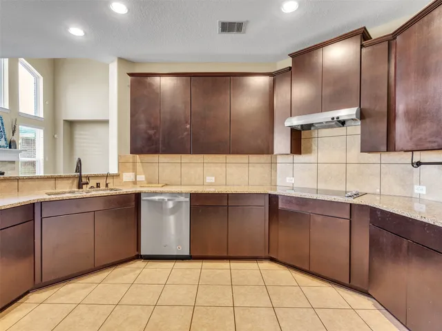 a large kitchen with kitchen island granite countertop a sink stainless steel appliances and cabinets