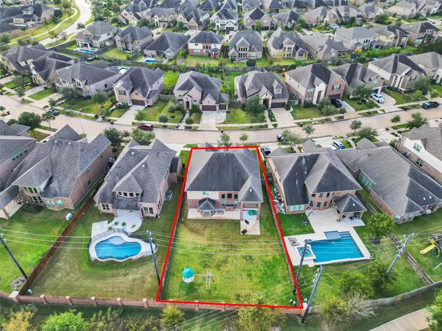 an aerial view of residential houses with outdoor space and parking