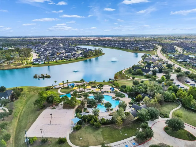 an aerial view of residential houses with outdoor space and lake view