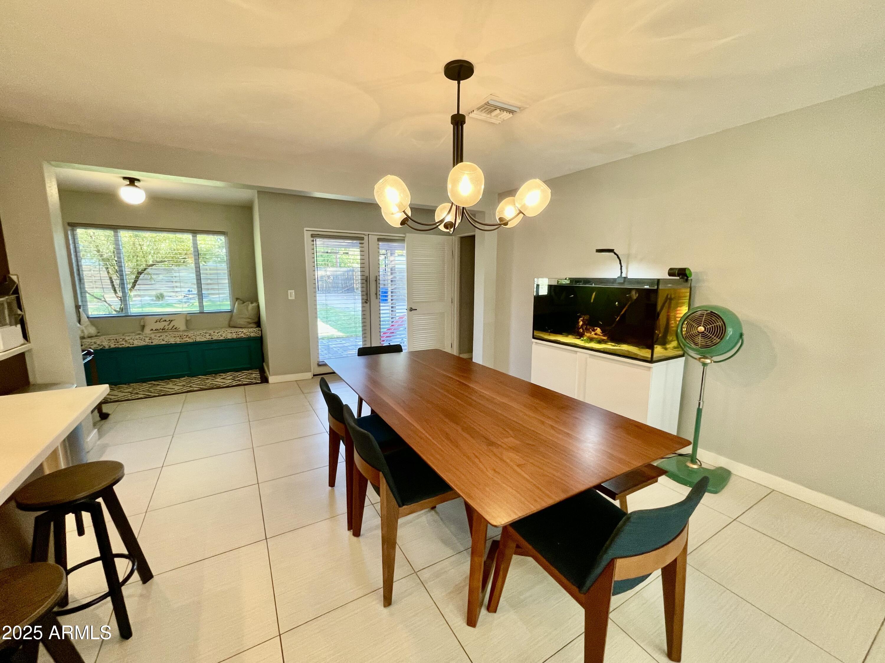1520 West Berridge Lane Phoenix, AZ 85015 - Photo 14 of 46 a dining room with wooden floor a chandelier a wooden table and chairs