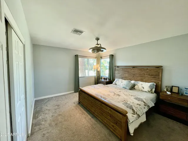 a bedroom with a large bed and a chandelier
